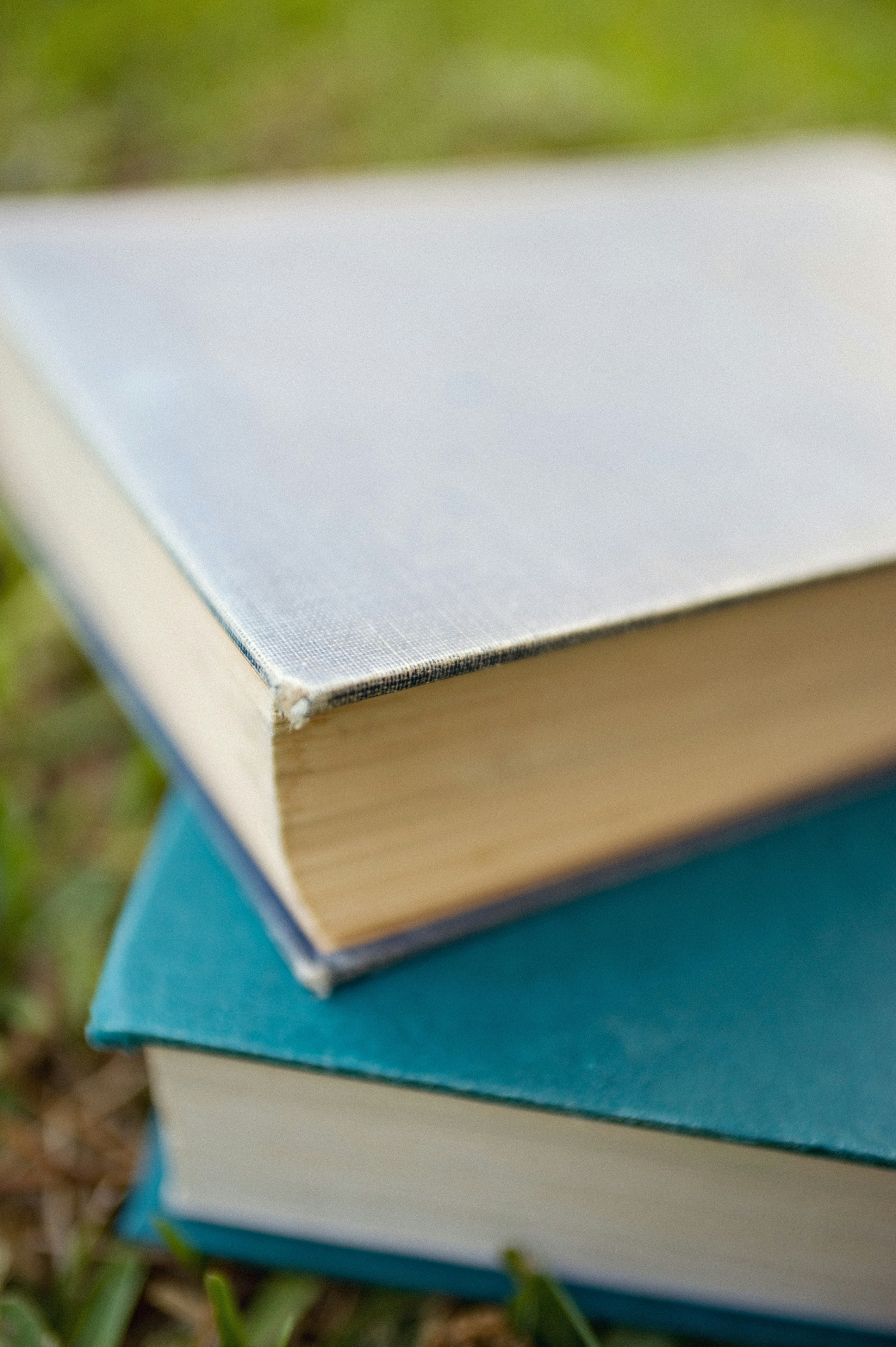 Stack of hardcover books in the grass